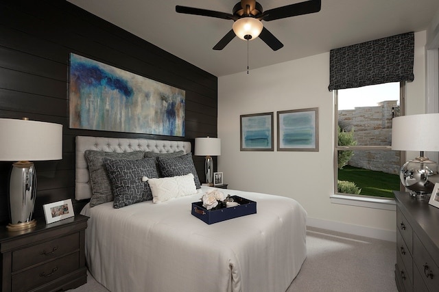 bedroom with wooden walls, light colored carpet, and ceiling fan