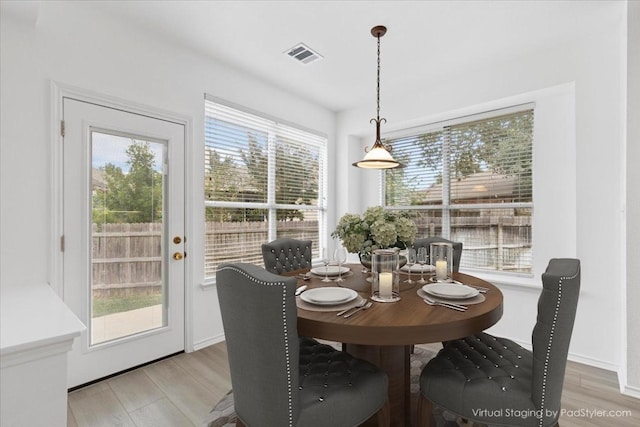 dining area with a wealth of natural light and light hardwood / wood-style flooring