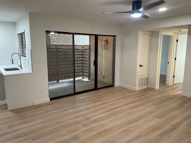 spare room with hardwood / wood-style flooring, sink, and ceiling fan