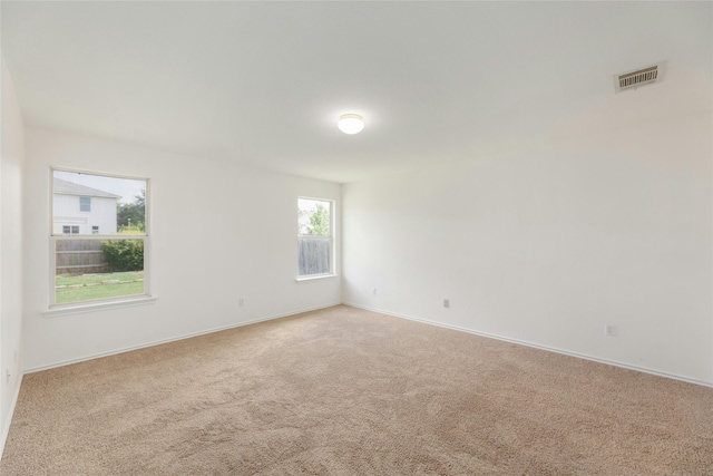 carpeted empty room featuring visible vents and baseboards