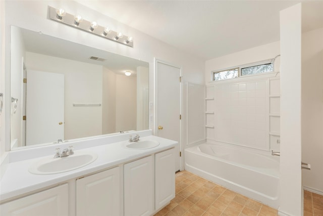 bathroom with double vanity, tub / shower combination, a sink, and visible vents