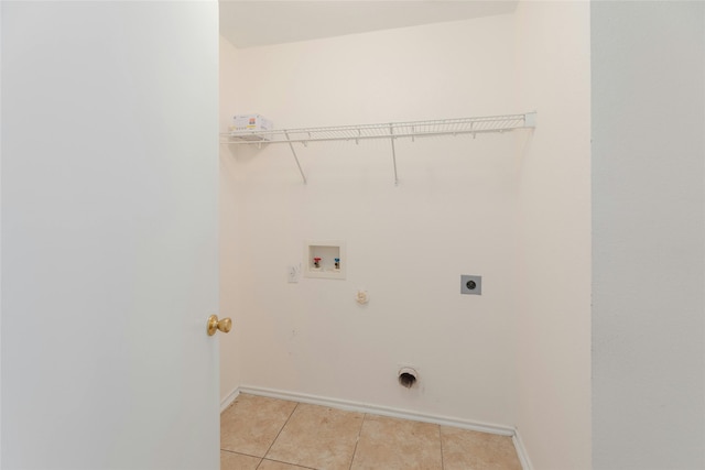 clothes washing area with light tile patterned flooring, hookup for a washing machine, hookup for a gas dryer, hookup for an electric dryer, and laundry area