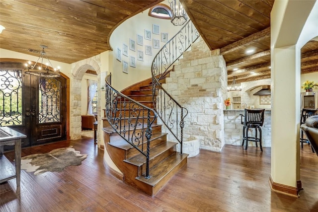 entrance foyer featuring wood-type flooring, a chandelier, and wooden ceiling