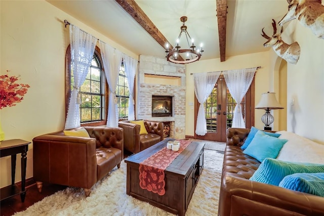 sitting room featuring an inviting chandelier, a fireplace, plenty of natural light, and beamed ceiling