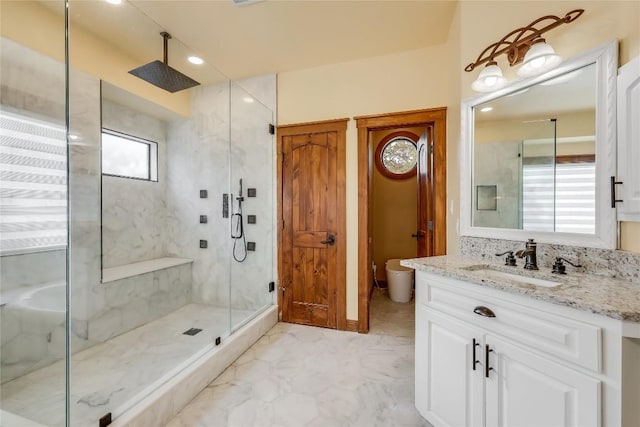 bathroom featuring vanity, a shower with door, and toilet