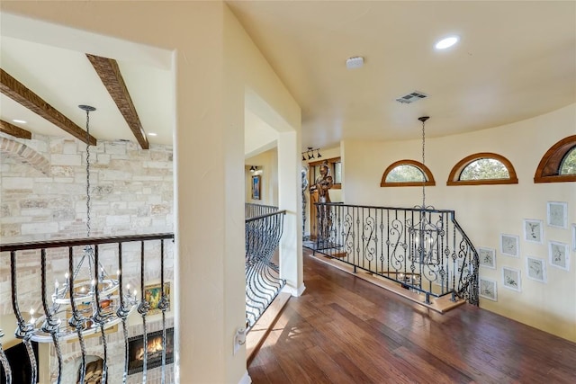 hall with beamed ceiling, dark hardwood / wood-style floors, and a chandelier