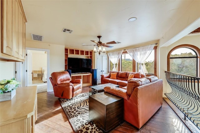 living room featuring ceiling fan and dark hardwood / wood-style flooring