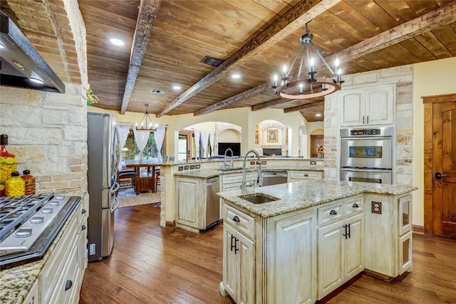 kitchen featuring wood ceiling, stainless steel appliances, a notable chandelier, a center island with sink, and decorative light fixtures