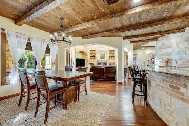 dining space featuring hardwood / wood-style floors, an inviting chandelier, wood ceiling, and beam ceiling