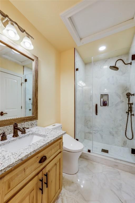 bathroom with vanity, toilet, and a shower with shower door