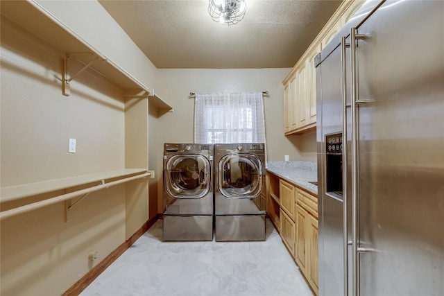 clothes washing area featuring washing machine and dryer, cabinets, and a textured ceiling