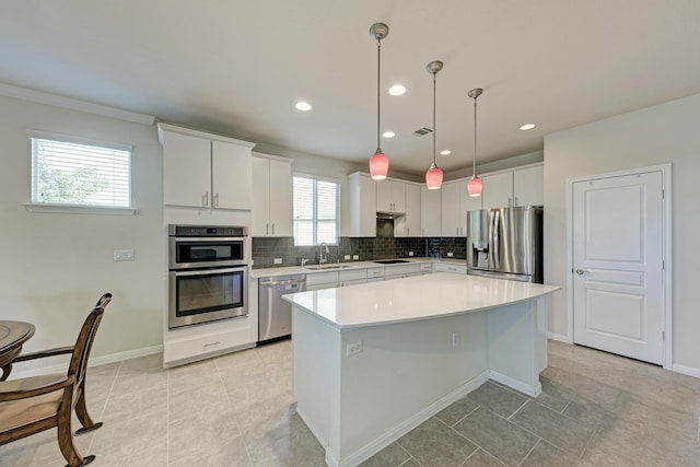 kitchen featuring white cabinetry, stainless steel appliances, sink, and a kitchen island