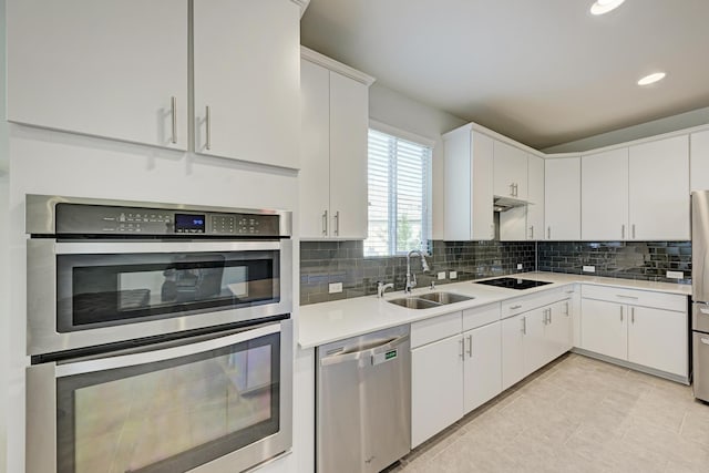 kitchen with stainless steel appliances, tasteful backsplash, sink, and white cabinets