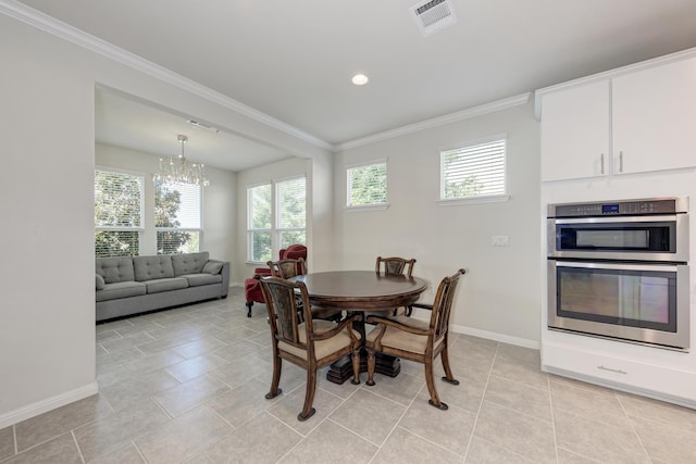 tiled dining area featuring ornamental molding and a chandelier