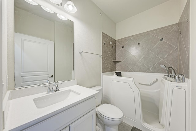 bathroom with vanity, tiled shower, and toilet