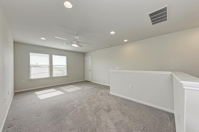 spare room with ceiling fan and light colored carpet