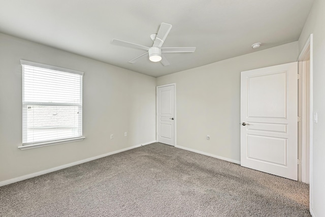 carpeted spare room with ceiling fan