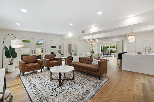 living area with visible vents, french doors, light wood-style flooring, and recessed lighting