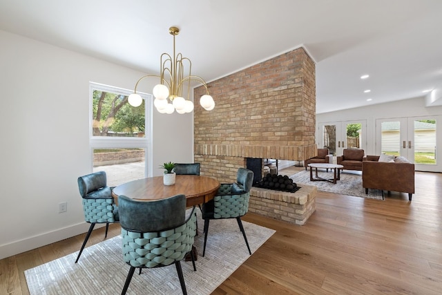 dining space with a healthy amount of sunlight, baseboards, wood finished floors, and french doors