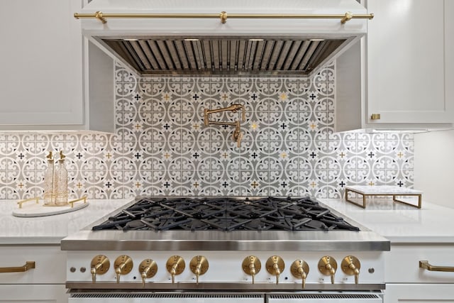 kitchen with light countertops, tasteful backsplash, exhaust hood, and white cabinets