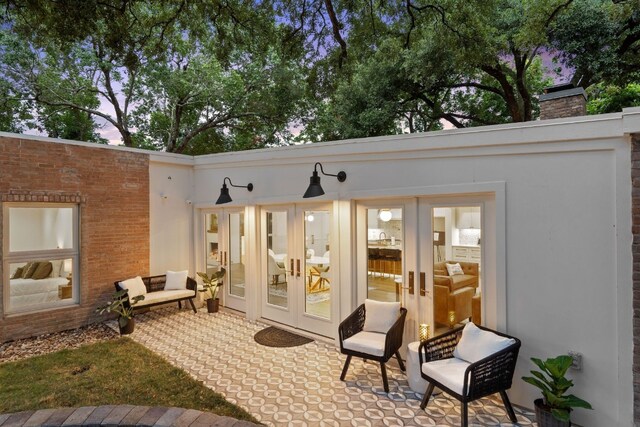 back of house featuring a patio area, french doors, brick siding, and a chimney