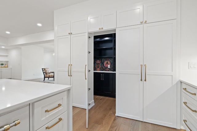 kitchen featuring light wood-style flooring, white cabinets, light countertops, and recessed lighting