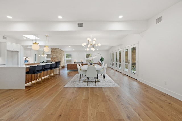 dining room with light wood-style floors, recessed lighting, visible vents, and an inviting chandelier