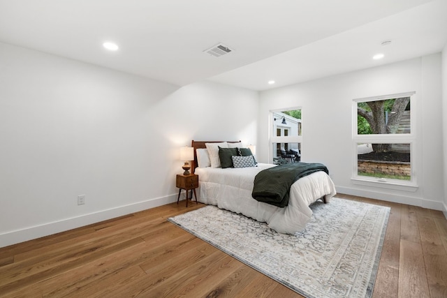 bedroom featuring recessed lighting, wood-type flooring, visible vents, and baseboards