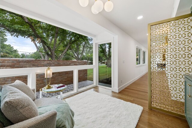 living area featuring a healthy amount of sunlight, baseboards, wood finished floors, and recessed lighting