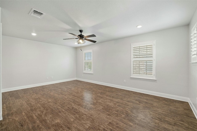 spare room featuring dark wood-type flooring and ceiling fan