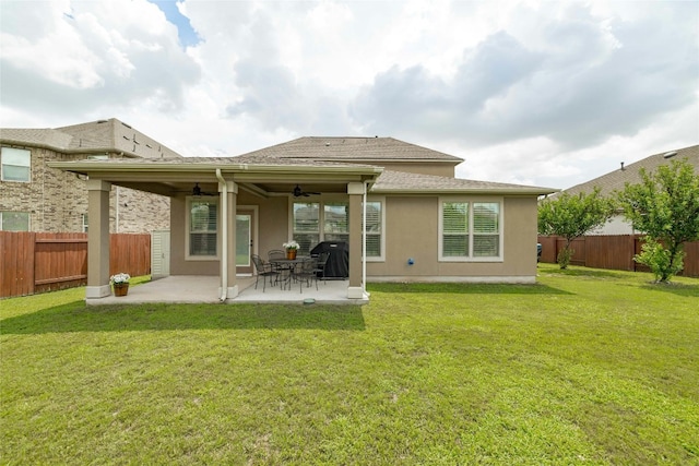 rear view of house featuring a patio, a yard, and ceiling fan