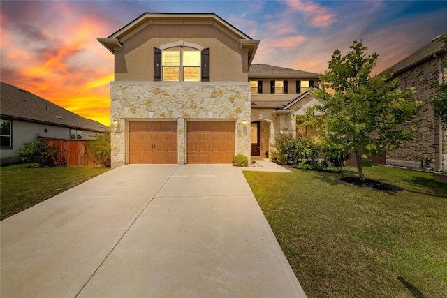 view of front of home featuring stone siding, a yard, concrete driveway, and stucco siding