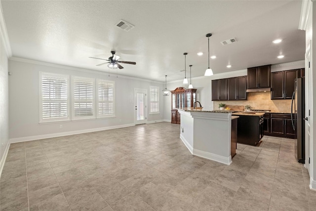 kitchen featuring light tile patterned floors, a wealth of natural light, and a center island with sink