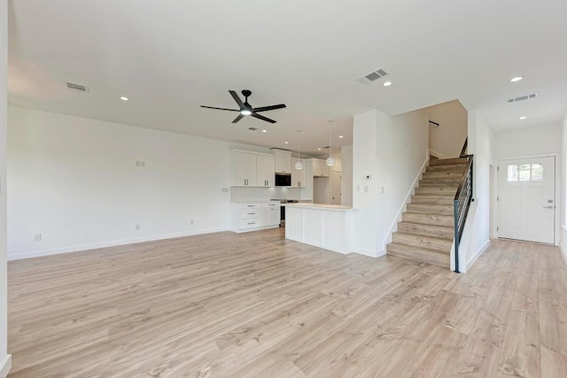 unfurnished living room featuring ceiling fan and light hardwood / wood-style floors