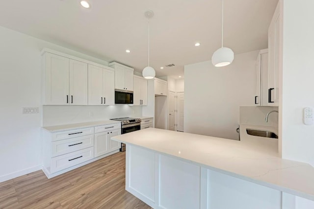 kitchen with sink, stainless steel range with electric cooktop, decorative light fixtures, kitchen peninsula, and white cabinets