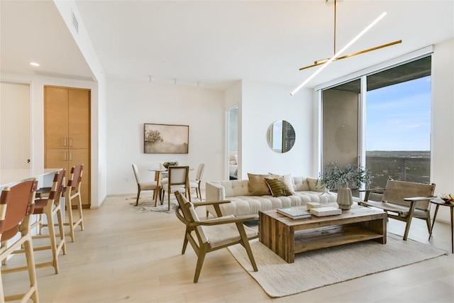 living room with a wall of windows and light wood-type flooring