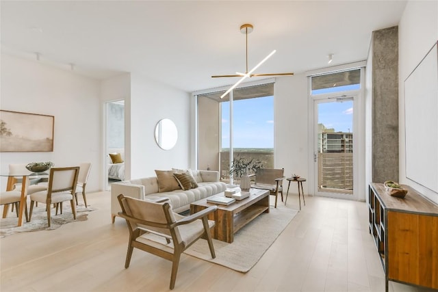 living room featuring light hardwood / wood-style flooring, floor to ceiling windows, and a chandelier