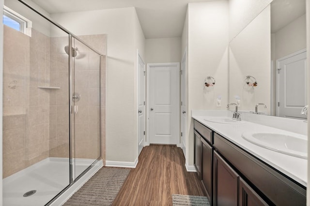 bathroom featuring hardwood / wood-style flooring, vanity, and a shower with door