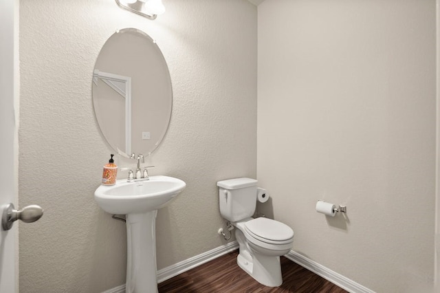 bathroom with hardwood / wood-style floors and toilet