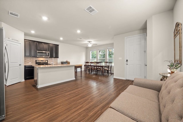 living room featuring ceiling fan and dark hardwood / wood-style floors