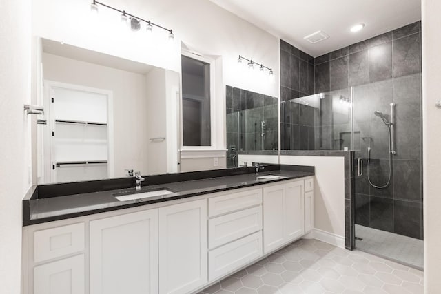 bathroom featuring tile patterned flooring, vanity, and a shower with door