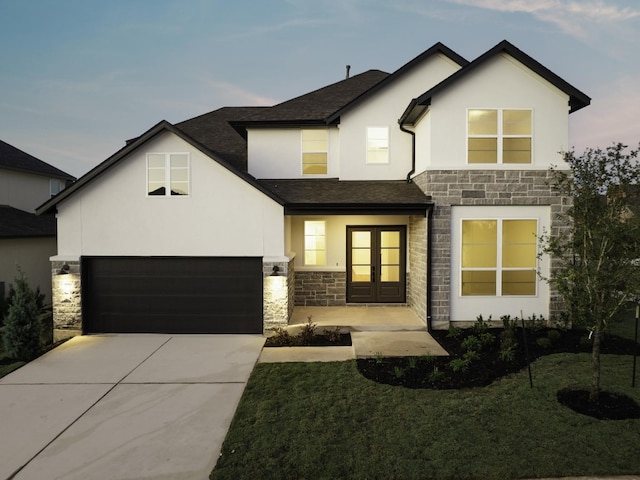 view of front of house with a lawn, a garage, and french doors