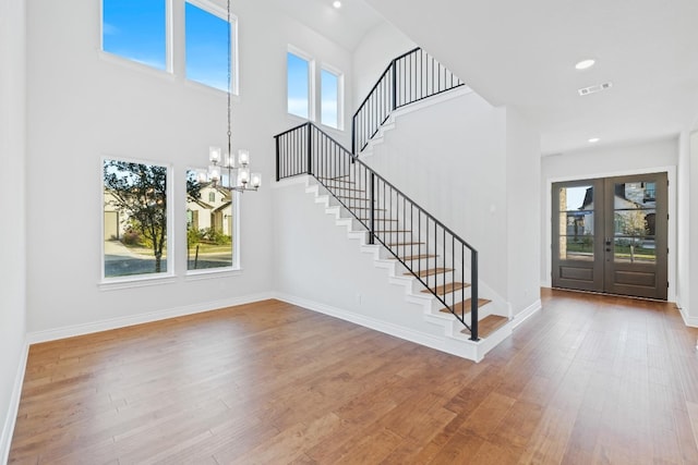 entryway with wood-type flooring, a wealth of natural light, and french doors