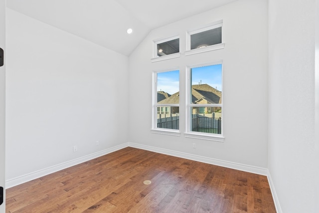 unfurnished room with hardwood / wood-style floors and vaulted ceiling