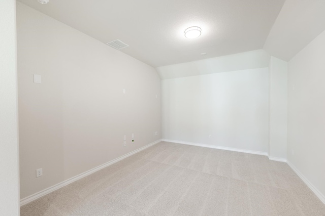 unfurnished room with light carpet and lofted ceiling