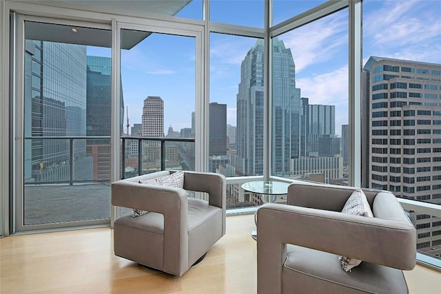 living room with a wall of windows and light wood-type flooring