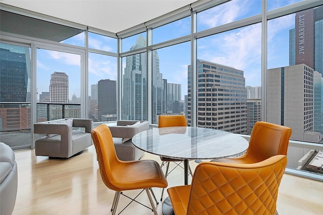 dining area featuring a wall of windows and light wood-type flooring