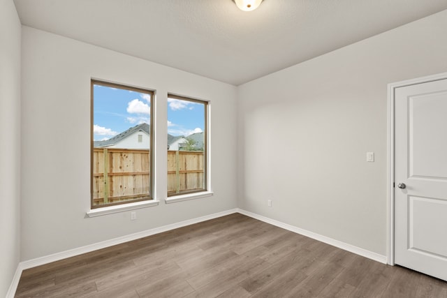 unfurnished room with wood-type flooring