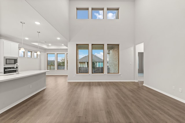 unfurnished living room with dark hardwood / wood-style flooring and sink