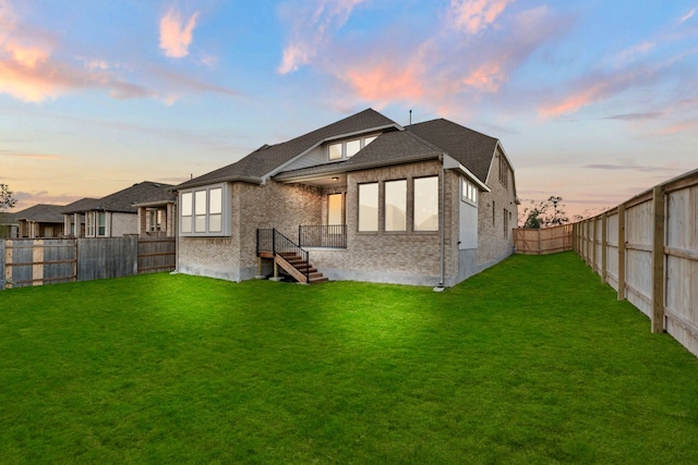 back house at dusk with a yard